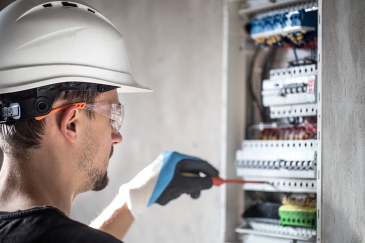 man-an-electrical-technician-working-in-switchboard-with-fuses-installation-and-connection-of-electrical-equipment (Pequeño)
