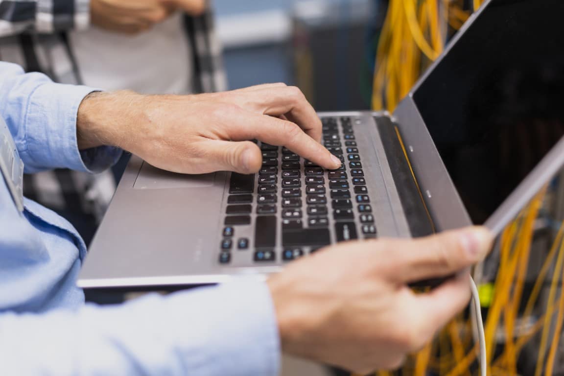 person typing on laptopn for security and surveillance solutions